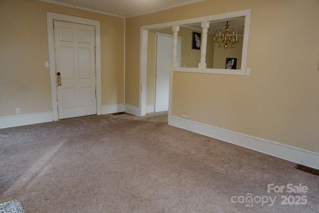 carpeted empty room with a notable chandelier and crown molding