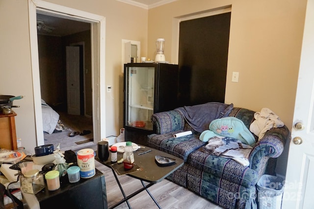 living room with light hardwood / wood-style floors and crown molding