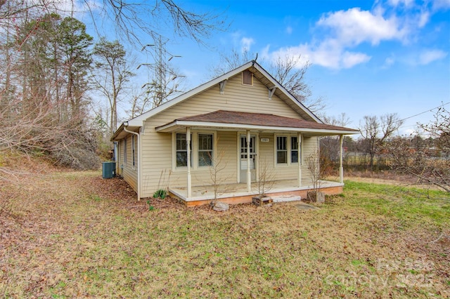 bungalow-style house with covered porch, a front lawn, and cooling unit