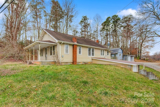 view of home's exterior featuring covered porch, crawl space, a lawn, and a chimney