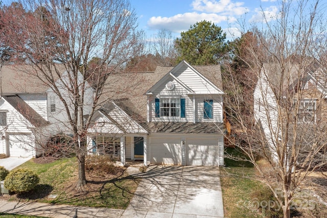 traditional-style home featuring a garage, a shingled roof, and concrete driveway