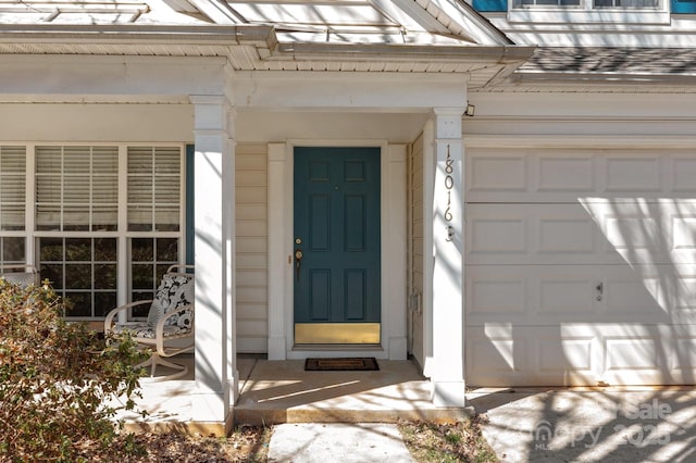 view of exterior entry with a shingled roof