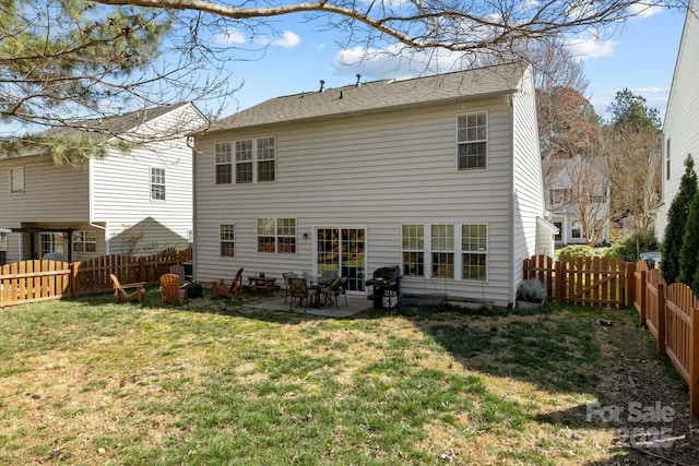 back of property featuring a yard, a patio, and a fenced backyard