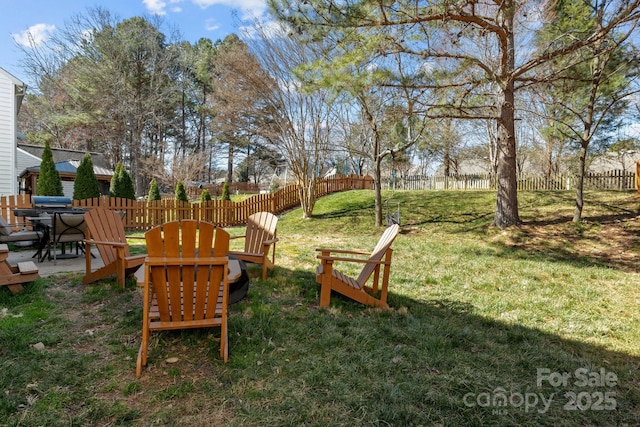 view of yard featuring a fenced backyard and a fire pit