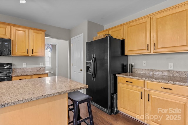 kitchen featuring a kitchen breakfast bar, dark wood-style flooring, light stone countertops, black appliances, and light brown cabinets