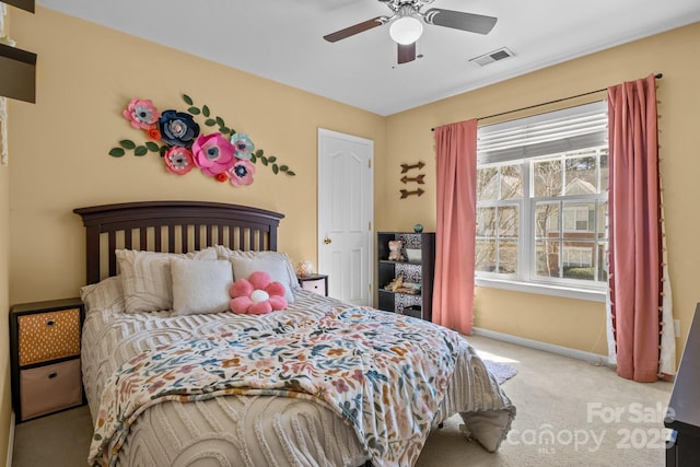 carpeted bedroom featuring baseboards, visible vents, and a ceiling fan