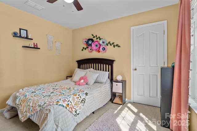 carpeted bedroom featuring ceiling fan and visible vents