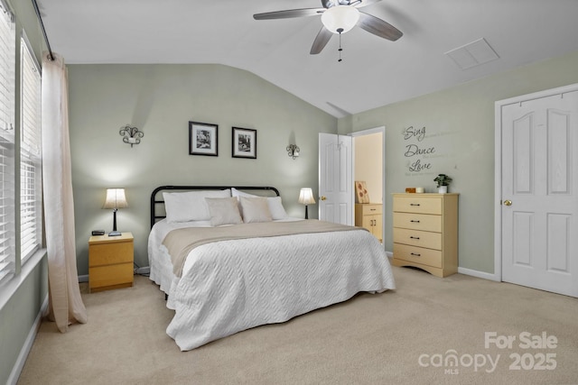 bedroom with lofted ceiling, light colored carpet, visible vents, baseboards, and a ceiling fan