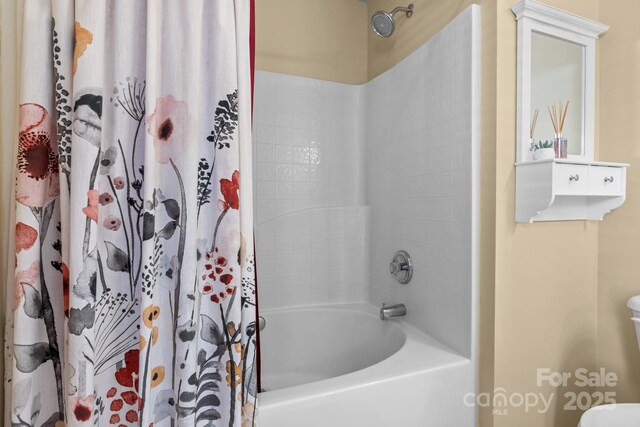 bathroom featuring toilet and shower / tub combo with curtain