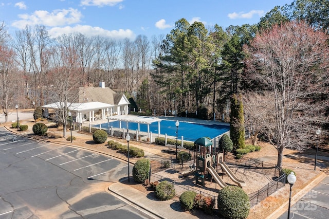 community pool featuring playground community and fence