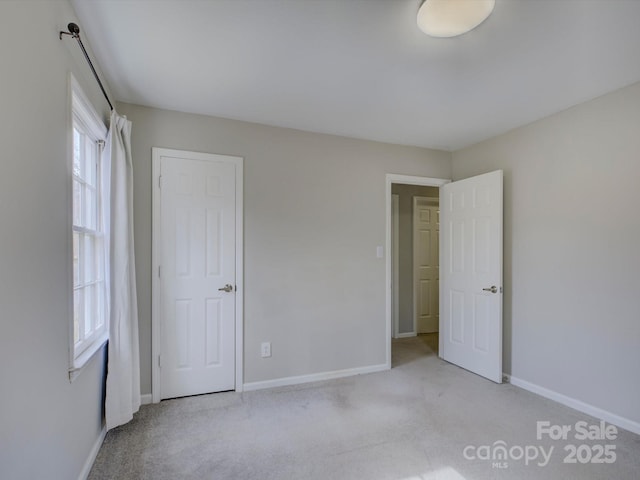 unfurnished bedroom featuring baseboards and carpet flooring