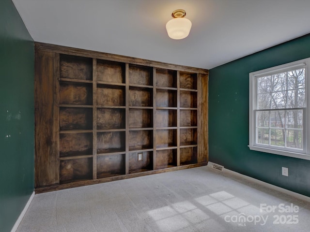 carpeted spare room with visible vents and baseboards