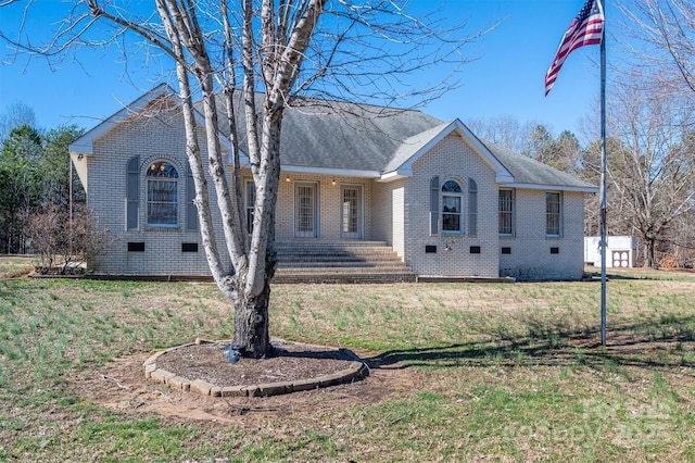 ranch-style home with roof with shingles, brick siding, crawl space, and a front yard