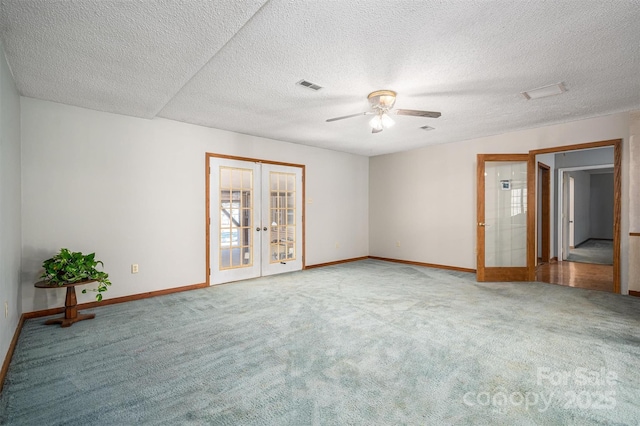 empty room featuring plenty of natural light, visible vents, carpet flooring, and french doors