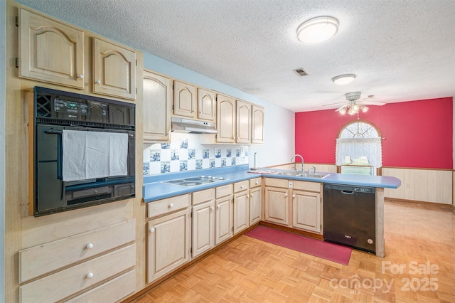 kitchen with light countertops, a sink, a peninsula, under cabinet range hood, and black appliances