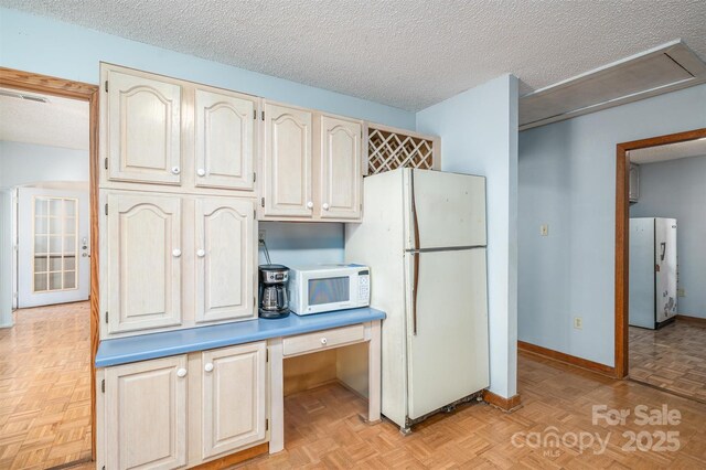 kitchen featuring white appliances, visible vents, baseboards, light countertops, and a textured ceiling