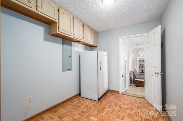 clothes washing area with electric panel, a textured ceiling, and baseboards