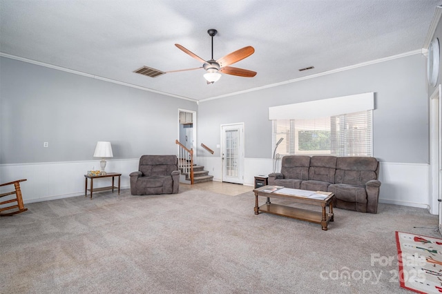 living room featuring a wainscoted wall, visible vents, and light carpet