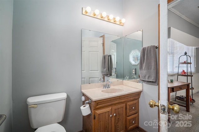 bathroom with vanity, toilet, and crown molding