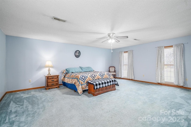 bedroom featuring carpet floors, visible vents, ceiling fan, a textured ceiling, and baseboards