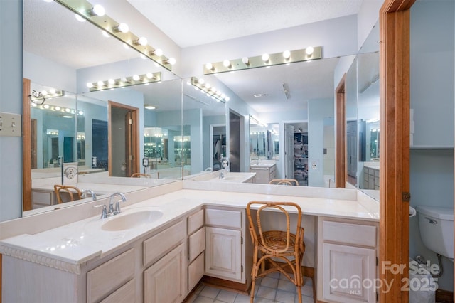 bathroom with a textured ceiling, toilet, and vanity