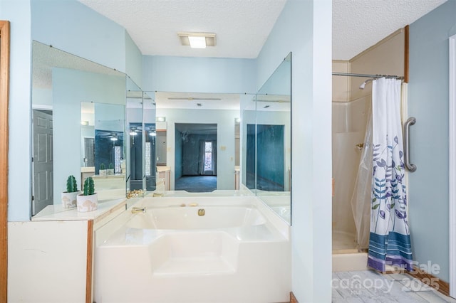 ensuite bathroom featuring a garden tub, a shower stall, a textured ceiling, and ensuite bathroom