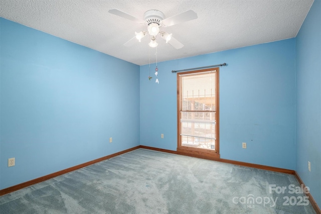 unfurnished room with carpet floors, a ceiling fan, baseboards, and a textured ceiling