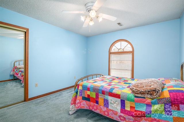 carpeted bedroom featuring a textured ceiling, a ceiling fan, visible vents, and baseboards