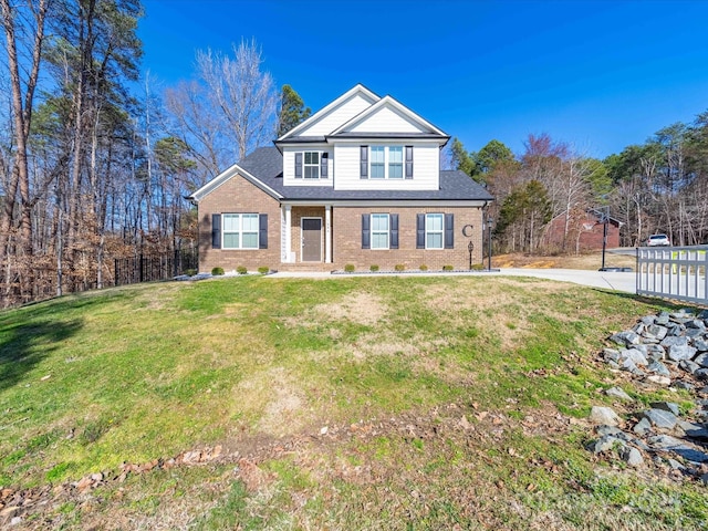 view of front of property featuring brick siding and a front yard