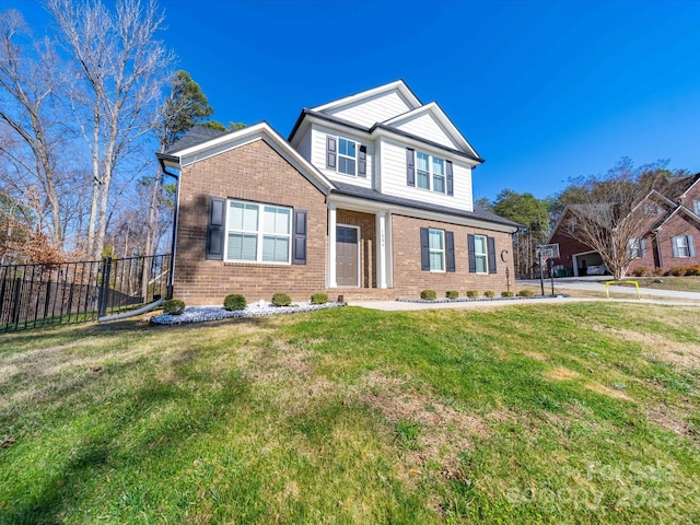 traditional-style home with a front yard, brick siding, and fence