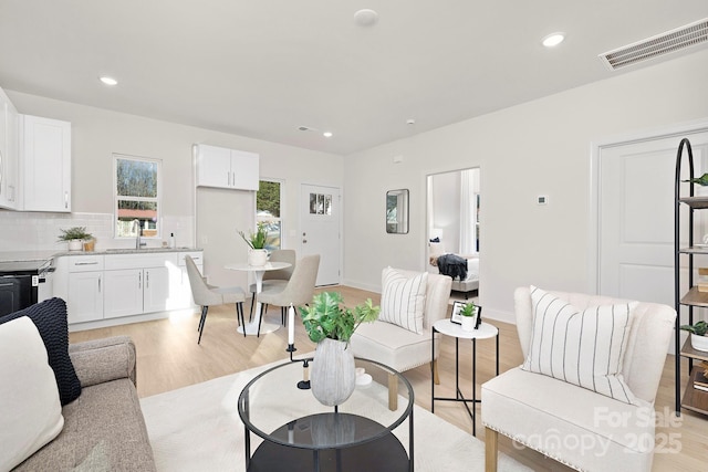 living room with light wood-type flooring and sink