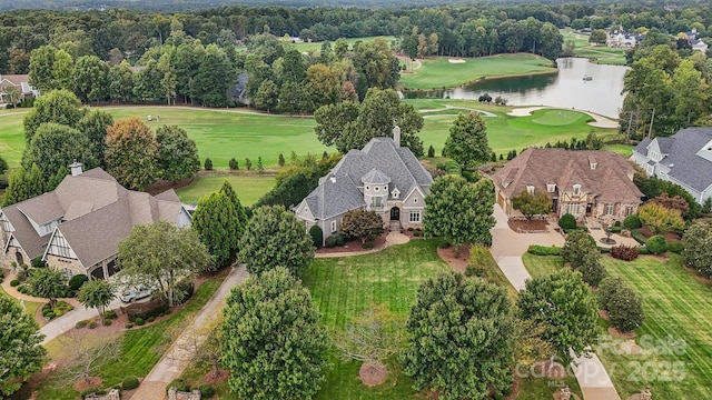 drone / aerial view with golf course view and a water view