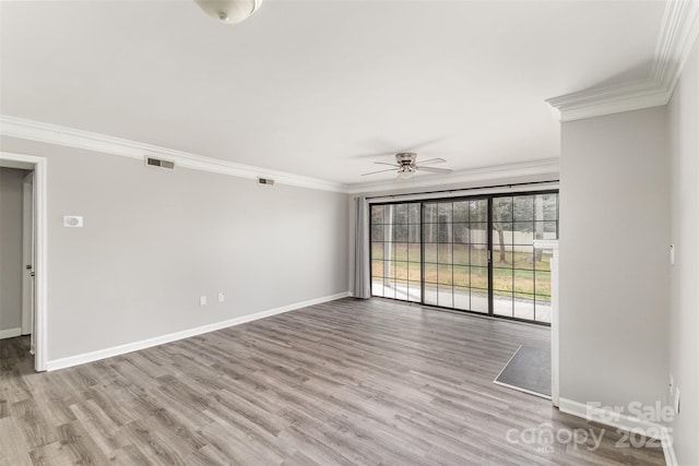 unfurnished room featuring baseboards, visible vents, and crown molding