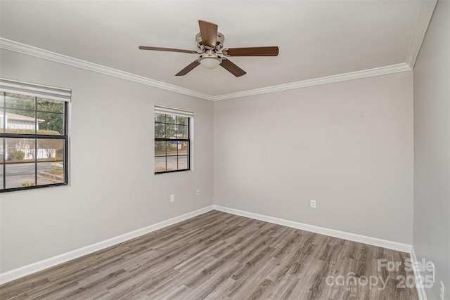 unfurnished room featuring light wood-type flooring, plenty of natural light, baseboards, and crown molding