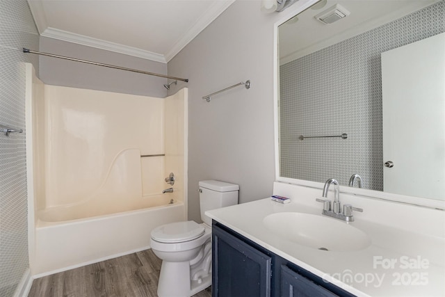 bathroom featuring bathtub / shower combination, toilet, ornamental molding, vanity, and wood finished floors