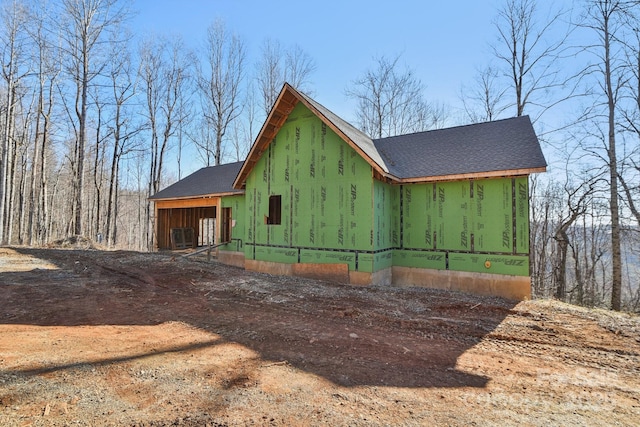 view of side of home featuring roof with shingles