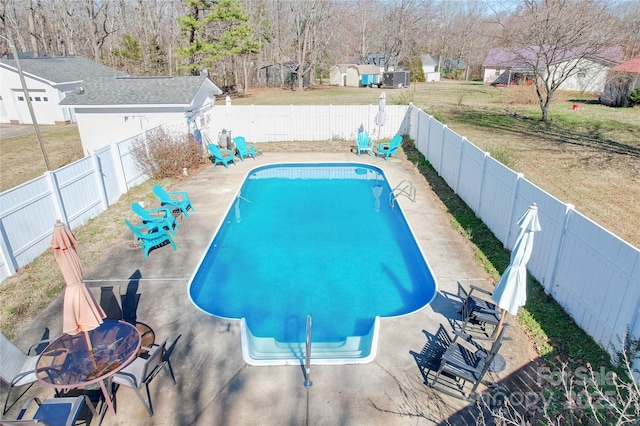 view of swimming pool featuring a lawn and an outdoor fire pit