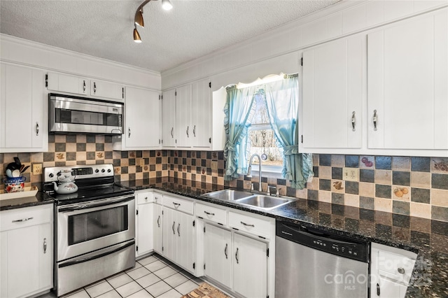 kitchen featuring sink, backsplash, white cabinetry, and appliances with stainless steel finishes