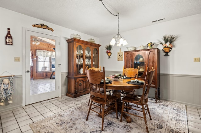 tiled dining space featuring a textured ceiling