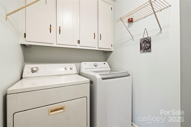 washroom with cabinets and washing machine and clothes dryer