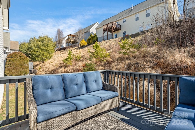 view of wooden balcony featuring a deck, a residential view, and an outdoor living space