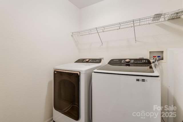 clothes washing area featuring laundry area and washer and clothes dryer