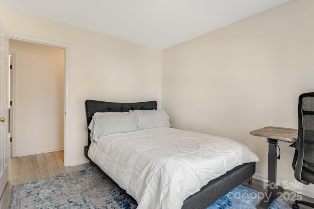 bedroom featuring baseboards and wood finished floors