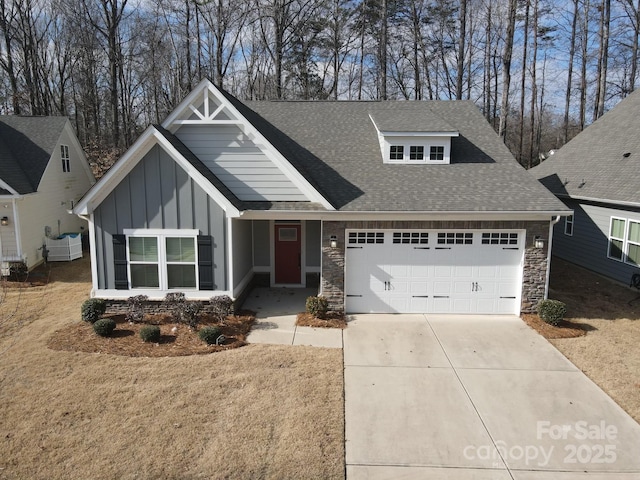 craftsman inspired home with concrete driveway, stone siding, roof with shingles, an attached garage, and board and batten siding