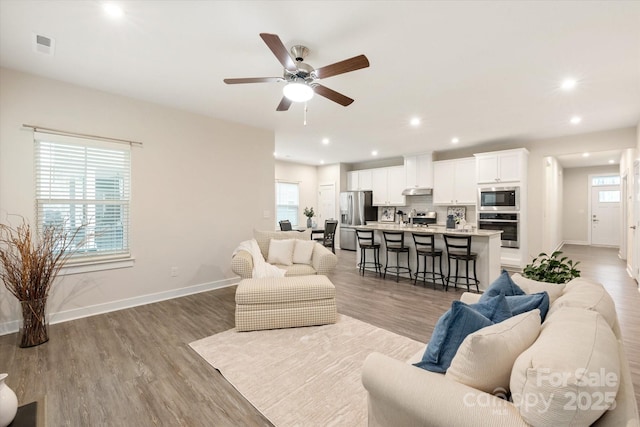 living room with recessed lighting, a healthy amount of sunlight, and wood finished floors