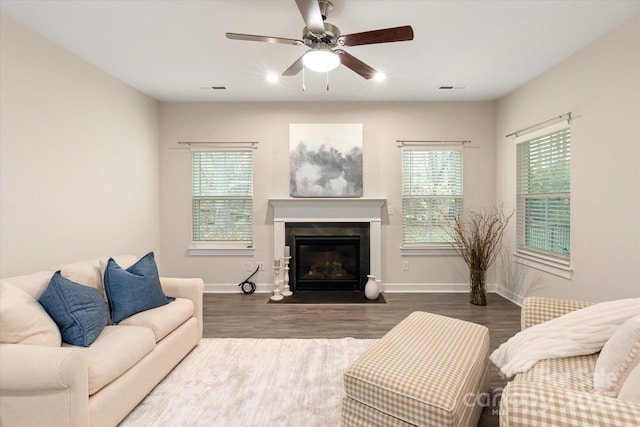 living area featuring a wealth of natural light, dark wood-type flooring, and visible vents