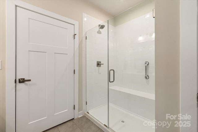 bathroom with a stall shower and tile patterned flooring