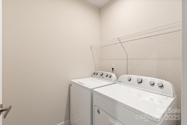 clothes washing area featuring laundry area, independent washer and dryer, and baseboards