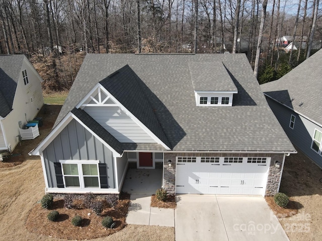 view of front of home with a garage, concrete driveway, a shingled roof, and board and batten siding