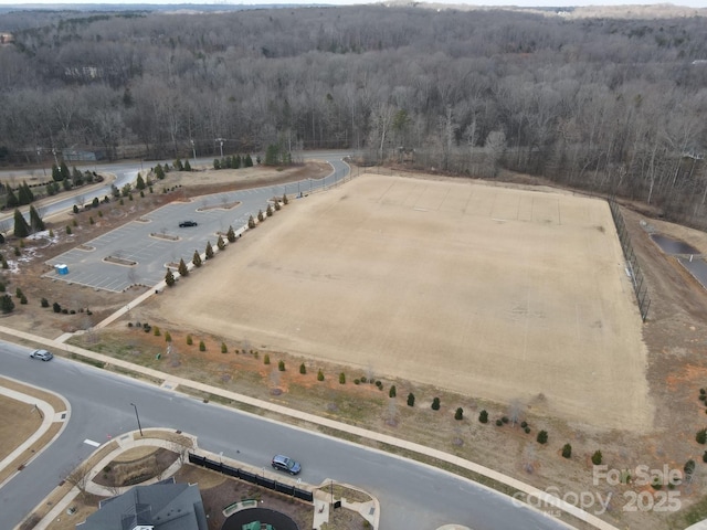 birds eye view of property with a view of trees